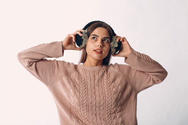 Foto jovens bonitas mulher segurando fones de ouvido de pele e camisola isolada