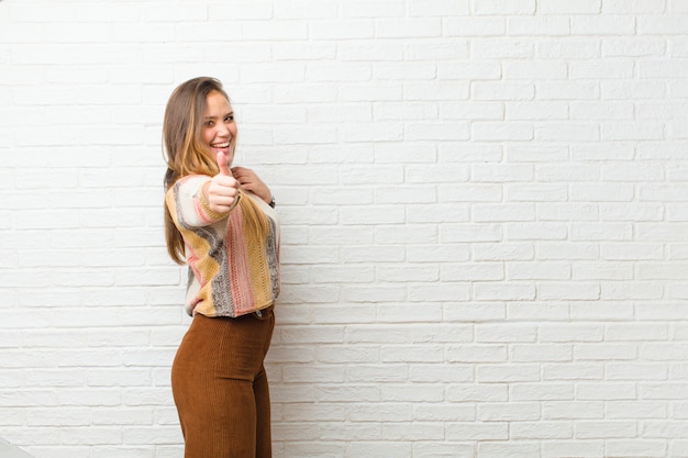 Jovens bonitas mulher sentindo orgulhoso, despreocupado, confiante e feliz, sorrindo positivamente com polegares para cima