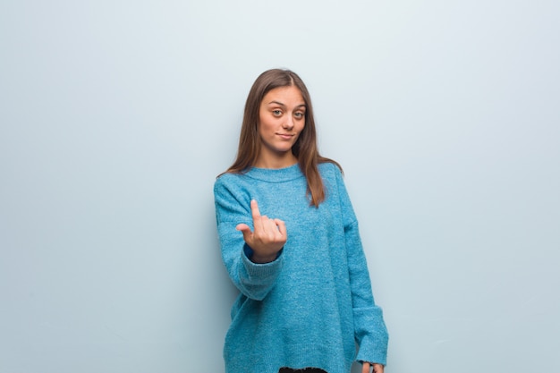 Jovens bonitas mulher vestindo um suéter azul, convidando para vir