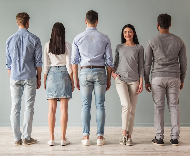 Jovens bonitos em pé em uma linha