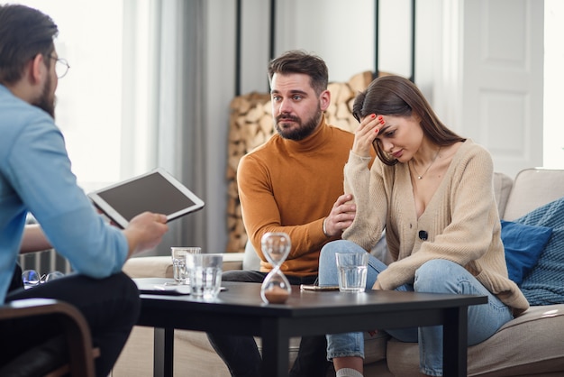Jovens brigando com raiva casal culpando um ao outro por problemas, dizendo que é sua culpa, discutindo com o psicólogo que está certo e errado, mal-entendido e egoísmo no casamento.