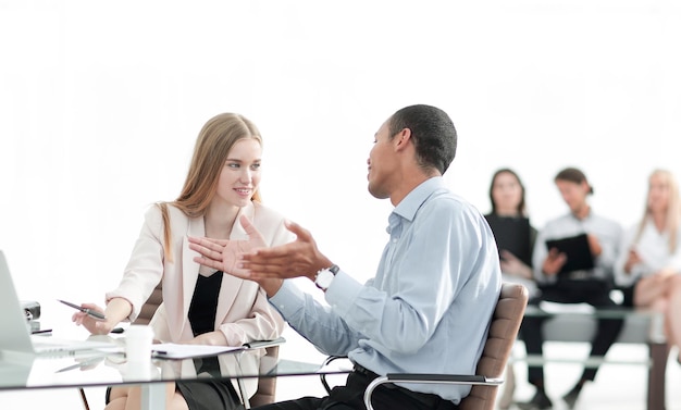 Jovens colegas de trabalho conversando atrás de uma mesa