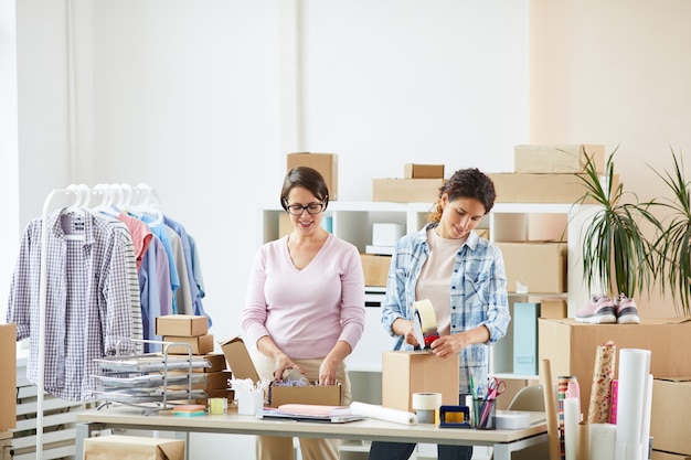 Jovens colegas femininas aguardando a mesa ao fazer encomendas para clientes