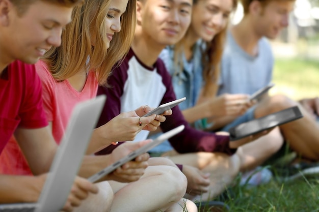 Jovens com gadgets em um parque