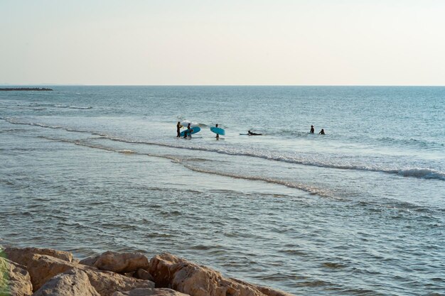 Jovens com pranchas de surf estão prestes a surfar no mar Surfistas carregando pranchas de surf indo para o mar