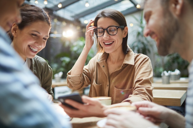 Jovens contemporâneos usando Smartphone no café