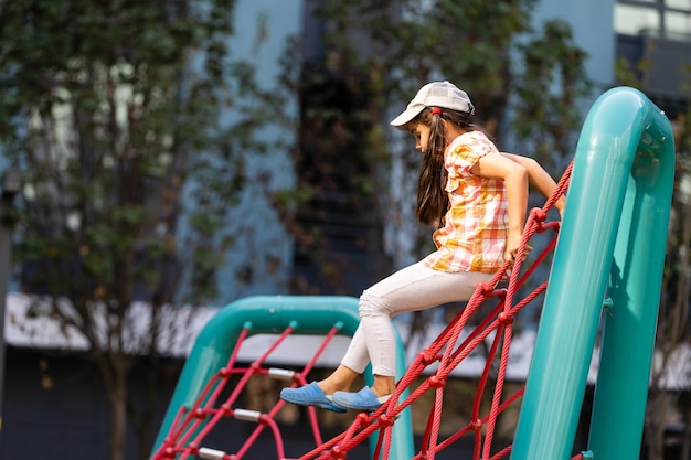 Jovens cutucando a cabeça através da atividade de corda de escalada usando-a como moldura.