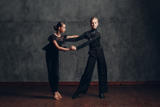 Jovens dançarinos do esporte profissional dançando no salão de baile Paso doble.