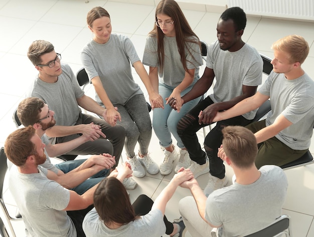 Jovens de mãos dadas em uma reunião de grupo