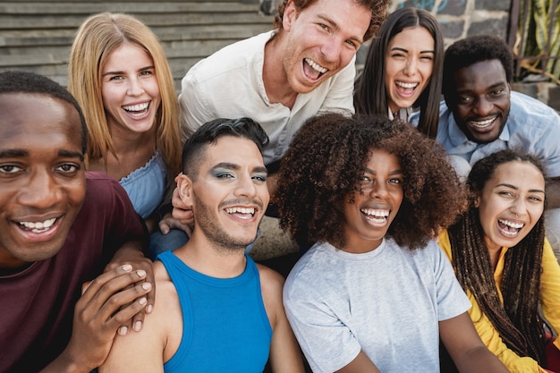 Foto jovens diversificados se divertindo ao ar livre, rindo juntos - foco no rosto do homem gay