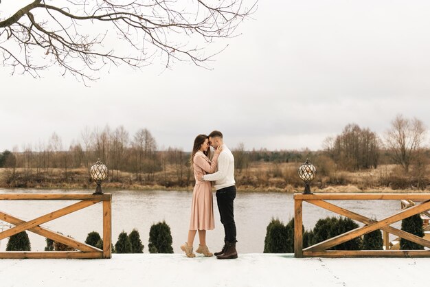 Jovens e belos amantes felizes, homem e mulher, amam a história no inverno com neve em um lugar pitoresco