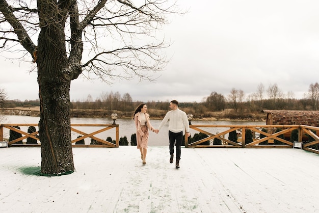 Jovens e belos amantes felizes, homem e mulher, amam a história no inverno com neve em um lugar pitoresco