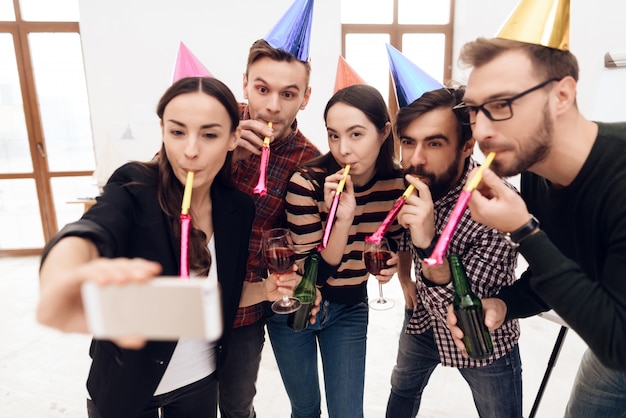 Jovens em bonés de férias fazem selfie.