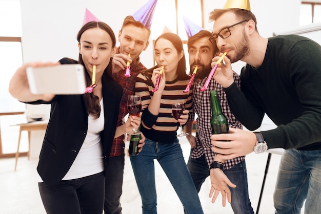 Jovens em bonés de férias fazem selfie.