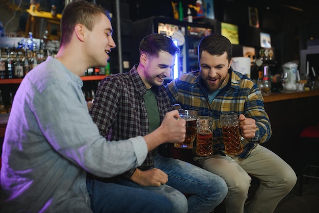 Jovens em roupas casuais estão conversando, rindo e bebendo enquanto estão sentados no balcão do bar no pub