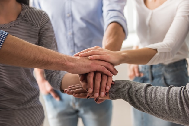 Jovens em roupas casuais, juntando as mãos