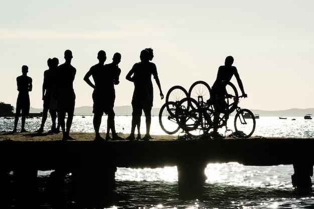 jovens em silhueta são vistos se divertindo na ponte Crush no final da tarde na cidade de Salvador Bahia