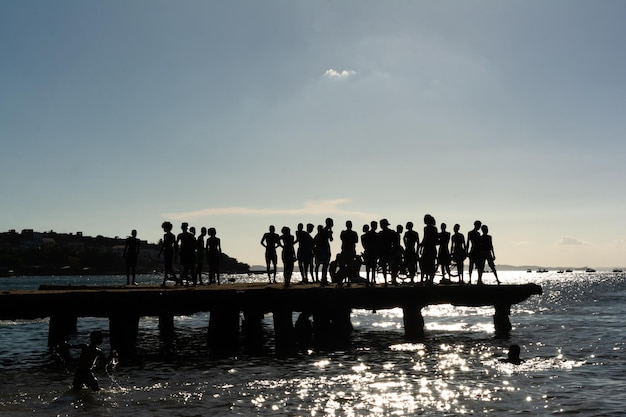 jovens em silhueta são vistos se divertindo na ponte Crush no final da tarde na cidade de Salvador Bahia