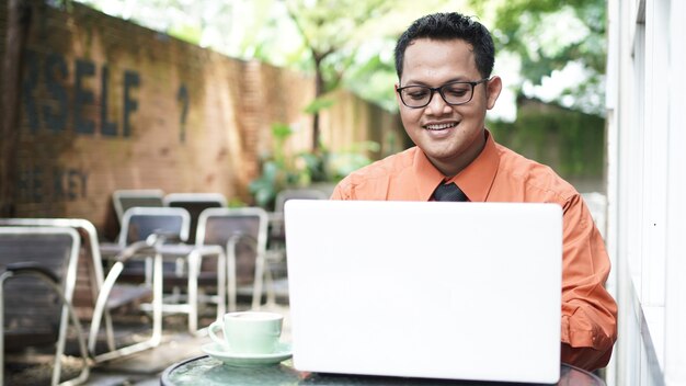 Jovens empreendedores asiáticos olhando para um laptop