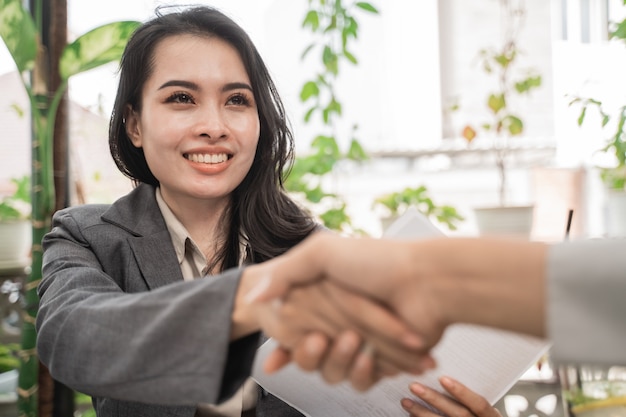 Jovens empresárias apertam as mãos em um café