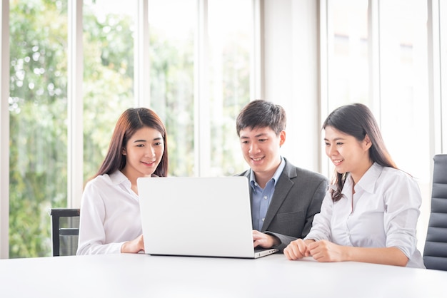 Jovens empresários asiáticos usando laptop