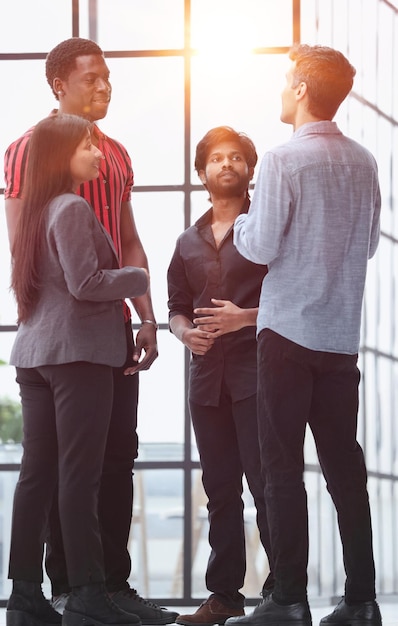 Jovens empresários discutindo sobre o relatório de negócios em pé no corredor do escritório