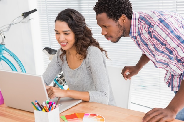 Jovens empresários que procuram um laptop