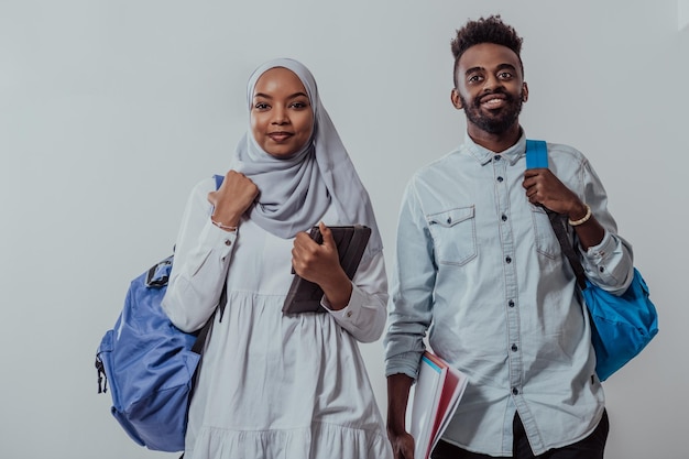 Jovens estudantes africanos casal andando de mulher vestindo negócios tradicionais de roupas de hijab muçulmano do sudão