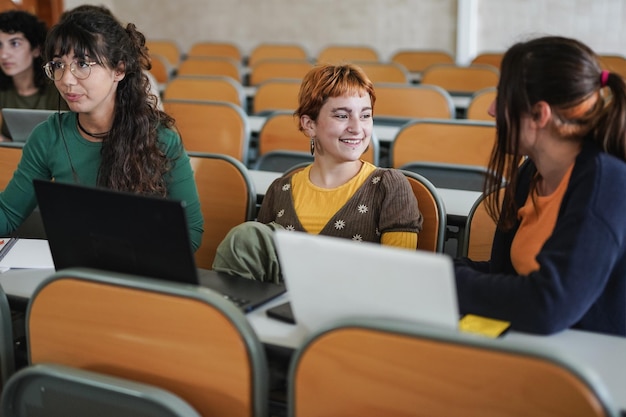 Jovens estudantes do sexo feminino aprendendo juntos dentro da sala de aula na escola universitária