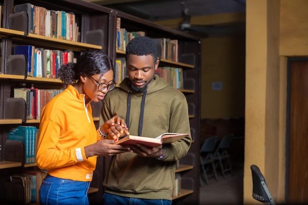 Jovens estudantes segurando um livro em uma biblioteca