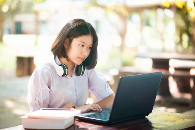 Jovens estudantes usando laptops em uma mesa e conectando-se ao conceito de educação e aprendizagem pela internet