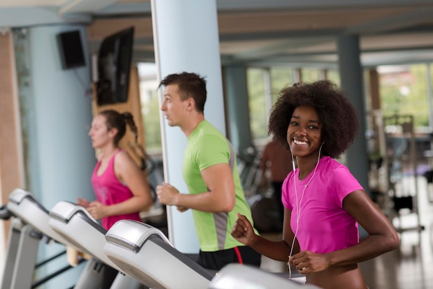 jovens exercitando um cardio na esteira correndo chine no ginásio moderno