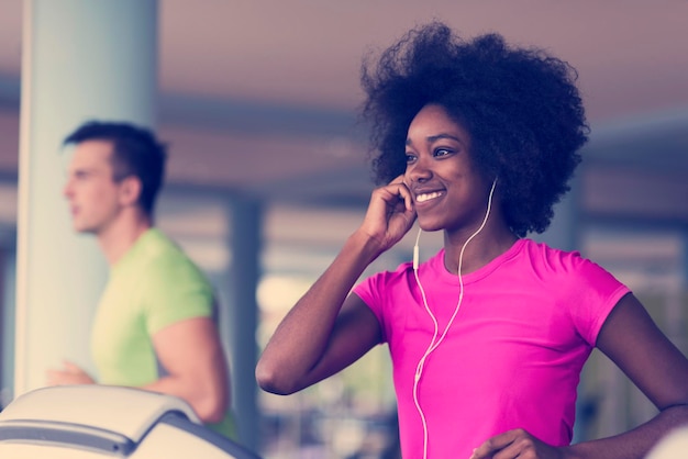 jovens exercitando um cardio na máquina de corrida de esteira no ginásio moderno