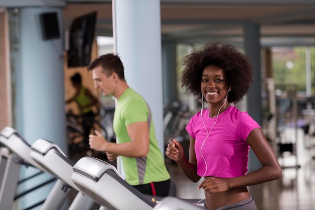 jovens exercitando um cardio na máquina de corrida de esteira no ginásio moderno