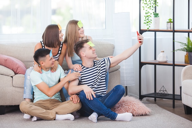 Jovens fazendo selfie dentro de casa. Grupo de amigos fazendo uma tentativa no smartphone. Pessoas tirando fotos de si mesmas.