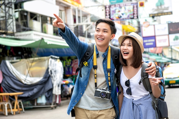 Jovens felizes asiáticos casal turistas mochileiros na estrada de khao san bangkok tailândia