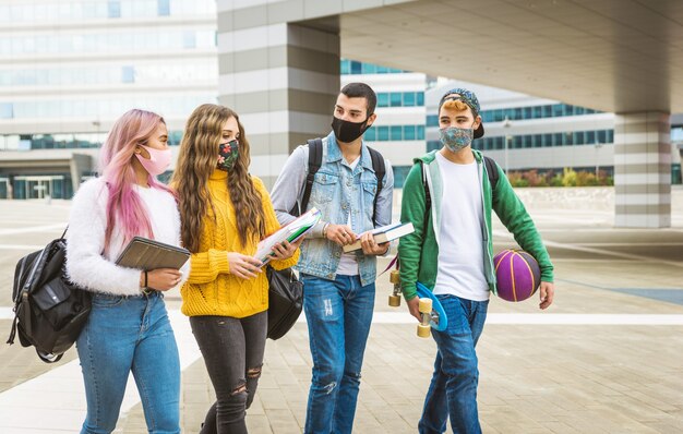 Jovens felizes se encontrando ao ar livre e usando máscaras durante a pandemia covid19