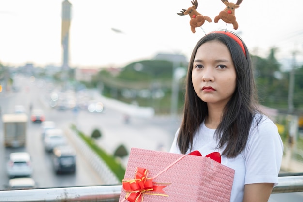 Jovens felizes usam chapéu de natal em plano de vista da cidade.