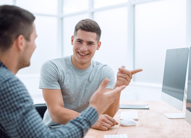 Jovens funcionários sentados na mesa do escritório