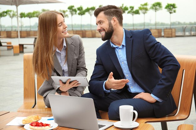 Jovens gerentes de marketing trabalhando no café ao ar livre