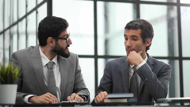 Jovens gerentes de sucesso à mesa no escritório