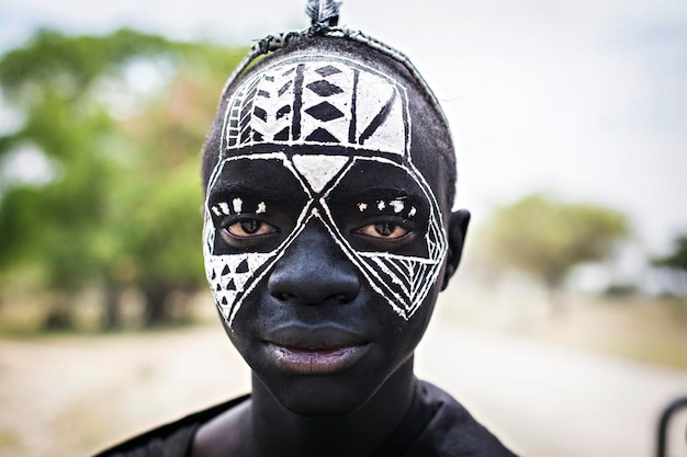 Jovens guerreiros Masai com pintura facial tradicional em preto e branco e roupas pretas, Arusha