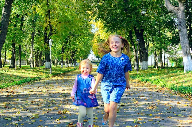 jovens irmãs felizes com gritos wow correr no parque de outono