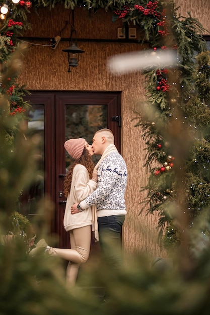 Jovens lindos e felizes casais sorridentes parados perto da casa decorada para o Natal Natal Ano Novo feriados de inverno