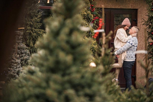 Jovens lindos e felizes casais sorridentes parados perto da casa decorada para o Natal Natal Ano Novo feriados de inverno