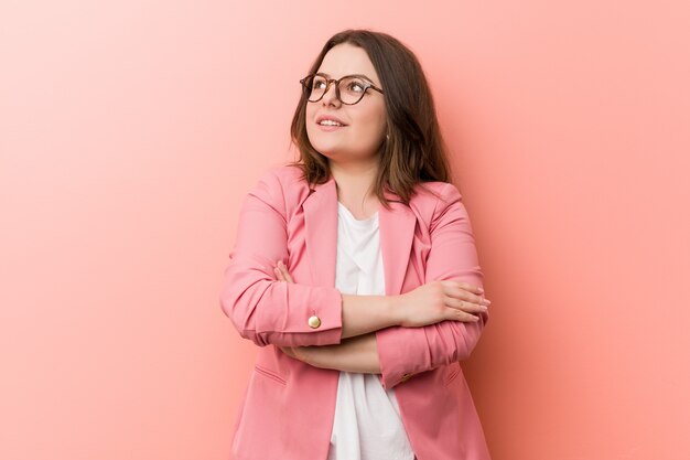 Jovens mais mulher caucasiana de negócios de tamanho sorrindo confiante com braços cruzados.