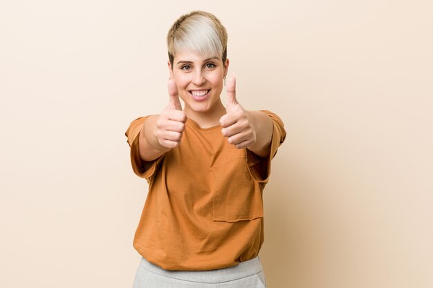 Jovens mais tamanho mulher com cabelo curto com polegares para cima, um brinde por algo, apoiar e respeitar o conceito.