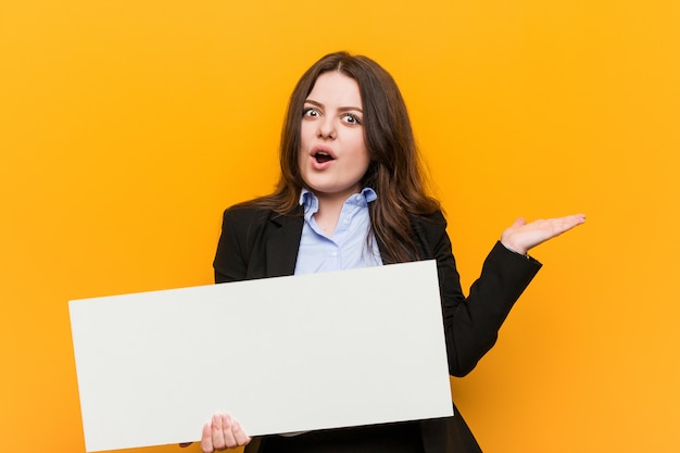 Jovens mais tamanho mulher curvilínea segurando um cartaz em branco branco na mão