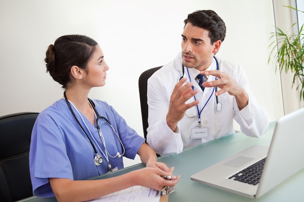 Jovens médicos trabalhando com um laptop