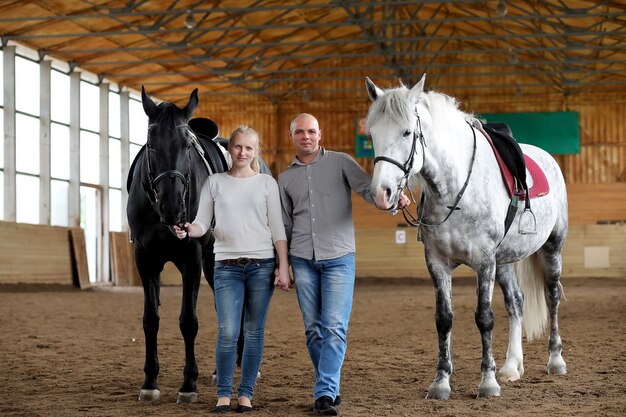 Jovens montados em um cavalo treinando em uma arena de madeira